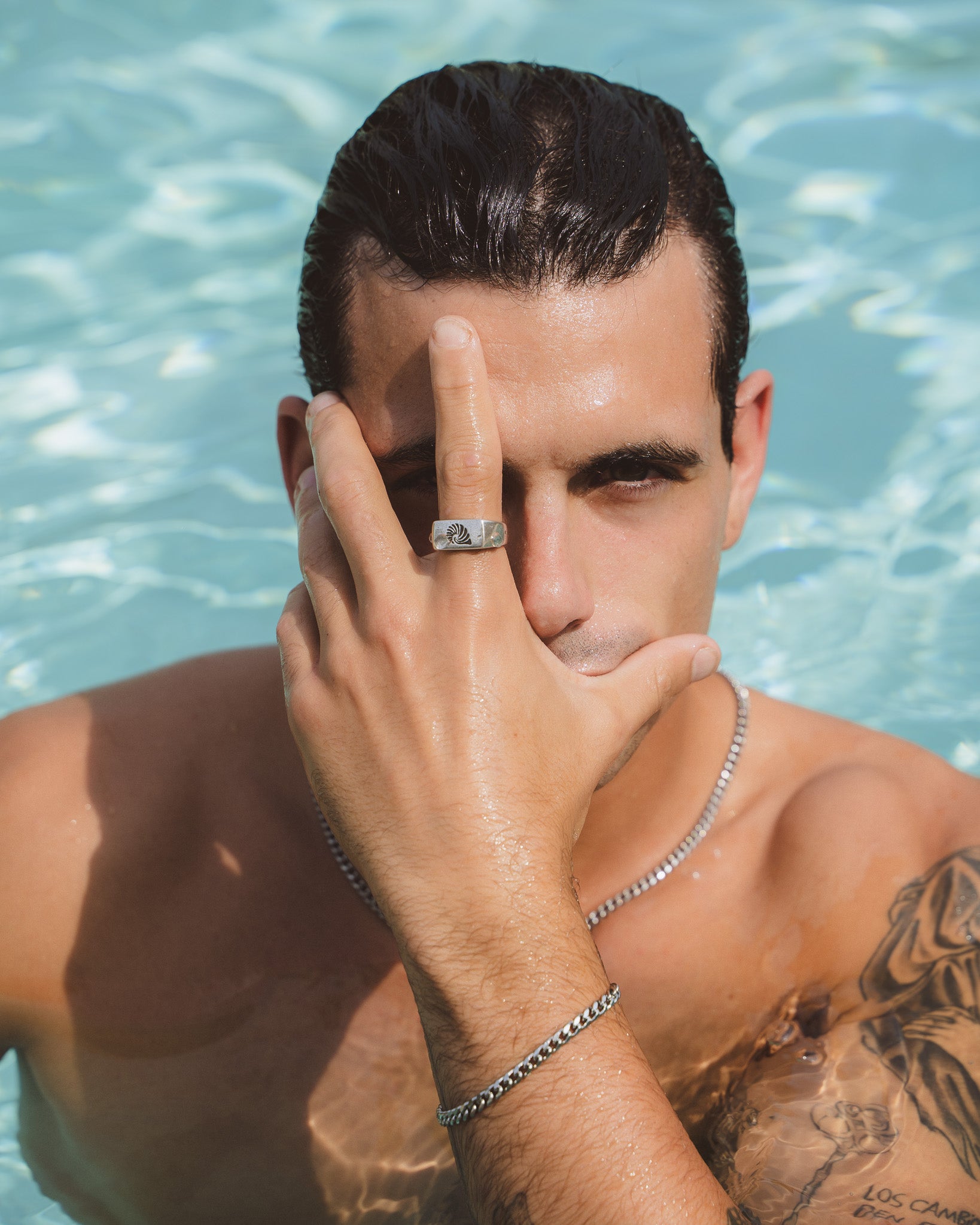 Shell Silver Ring on finger with sunburst design; arm and bracelet visible