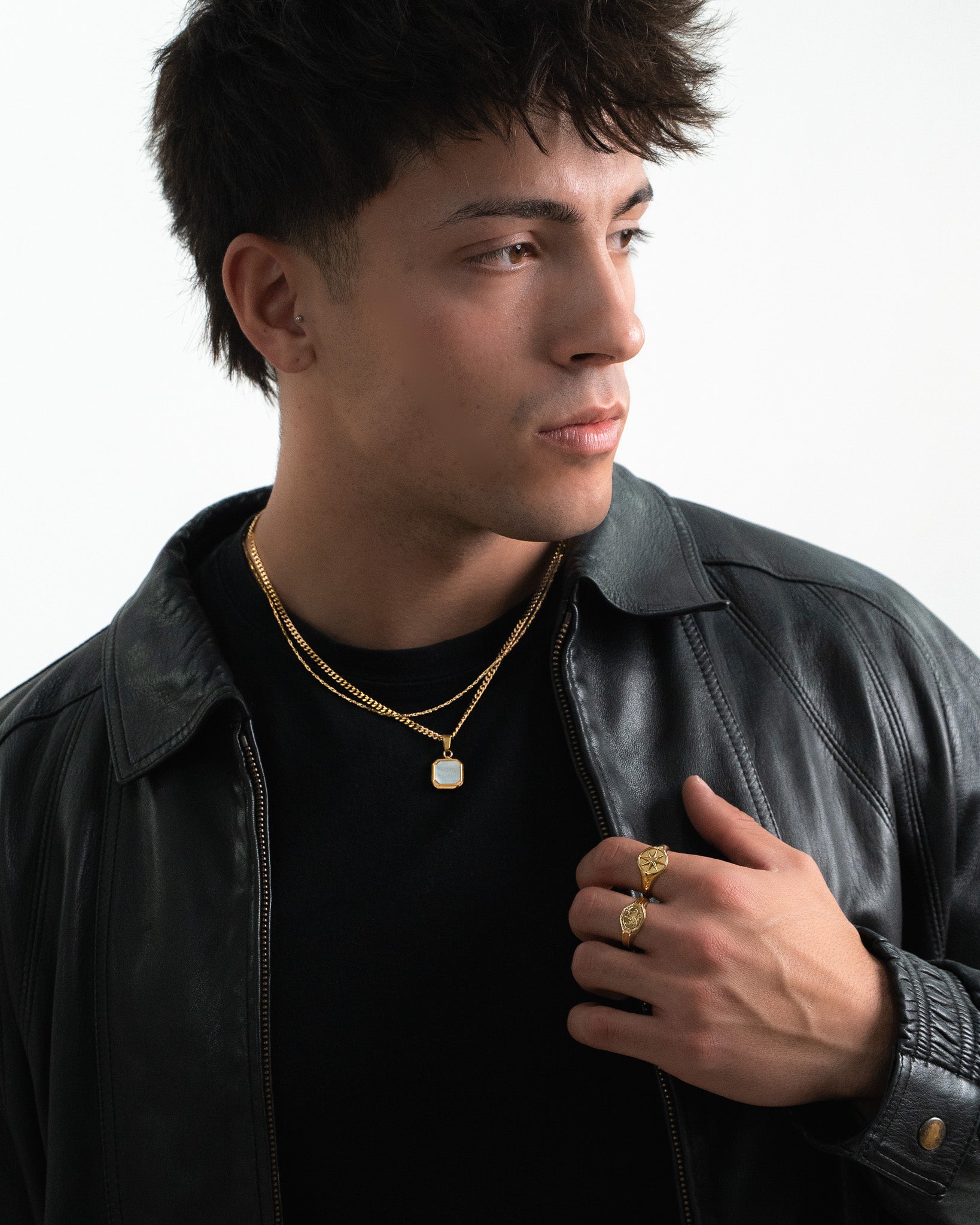 Man wearing Legacy Gold Ring on the finger with layered gold chains and a pendant