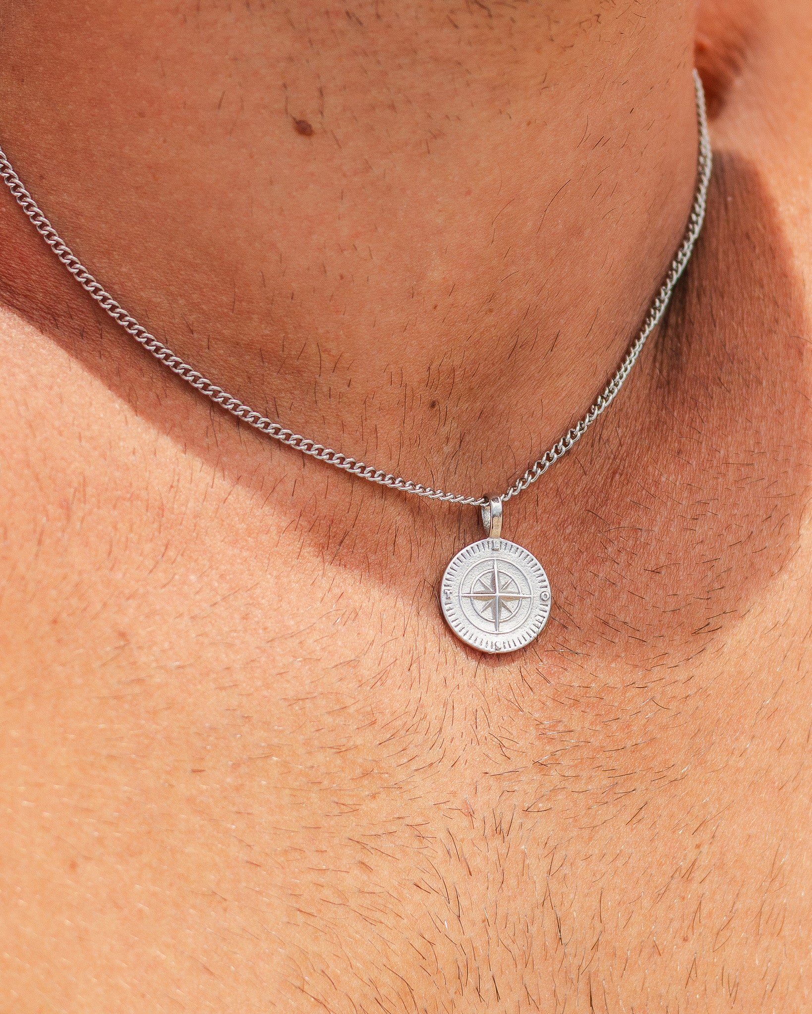 NORTHWALK silver necklace chain with compass pendant resting on the wearer's chest