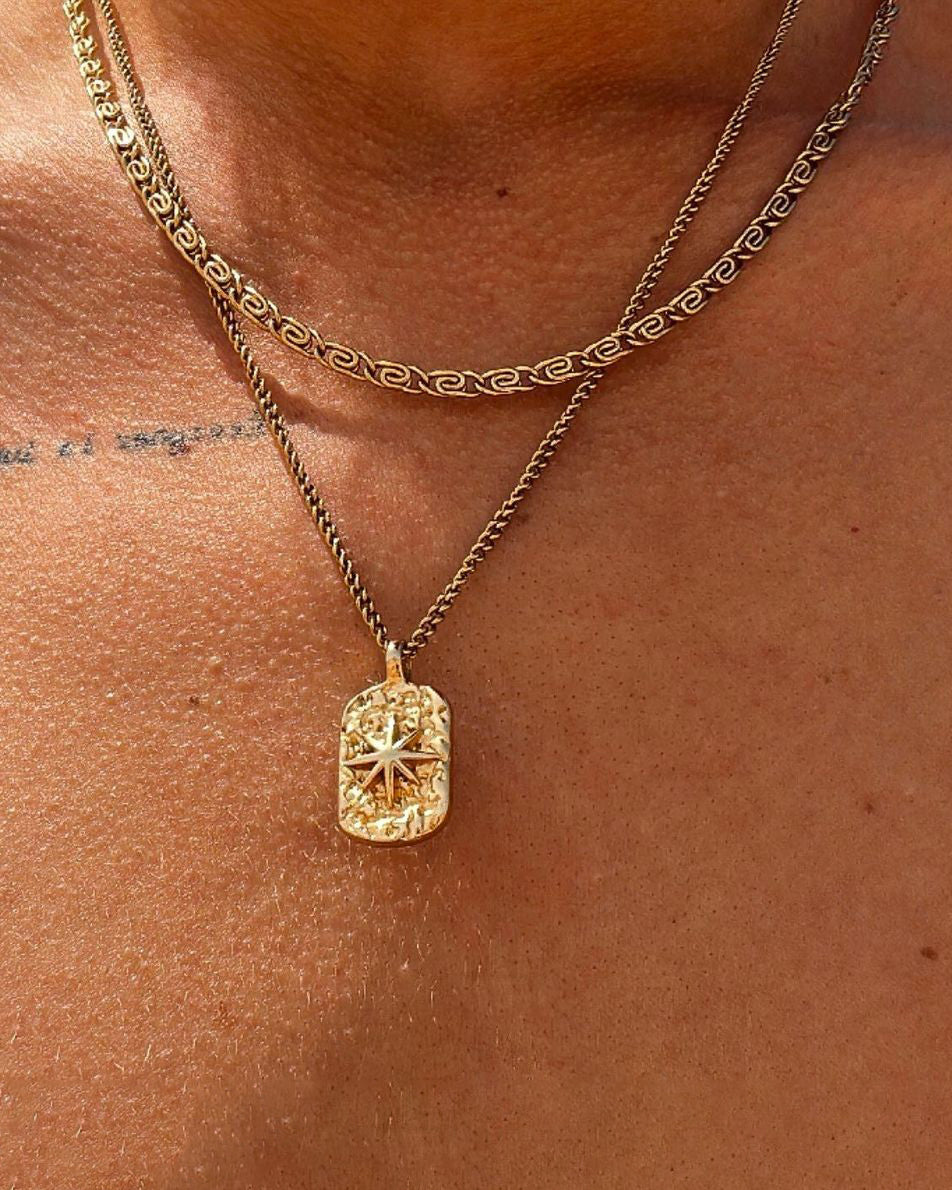 IBZ GOLD NECKLACE gold chain with a rectangular textured pendant featuring a raised starburst design