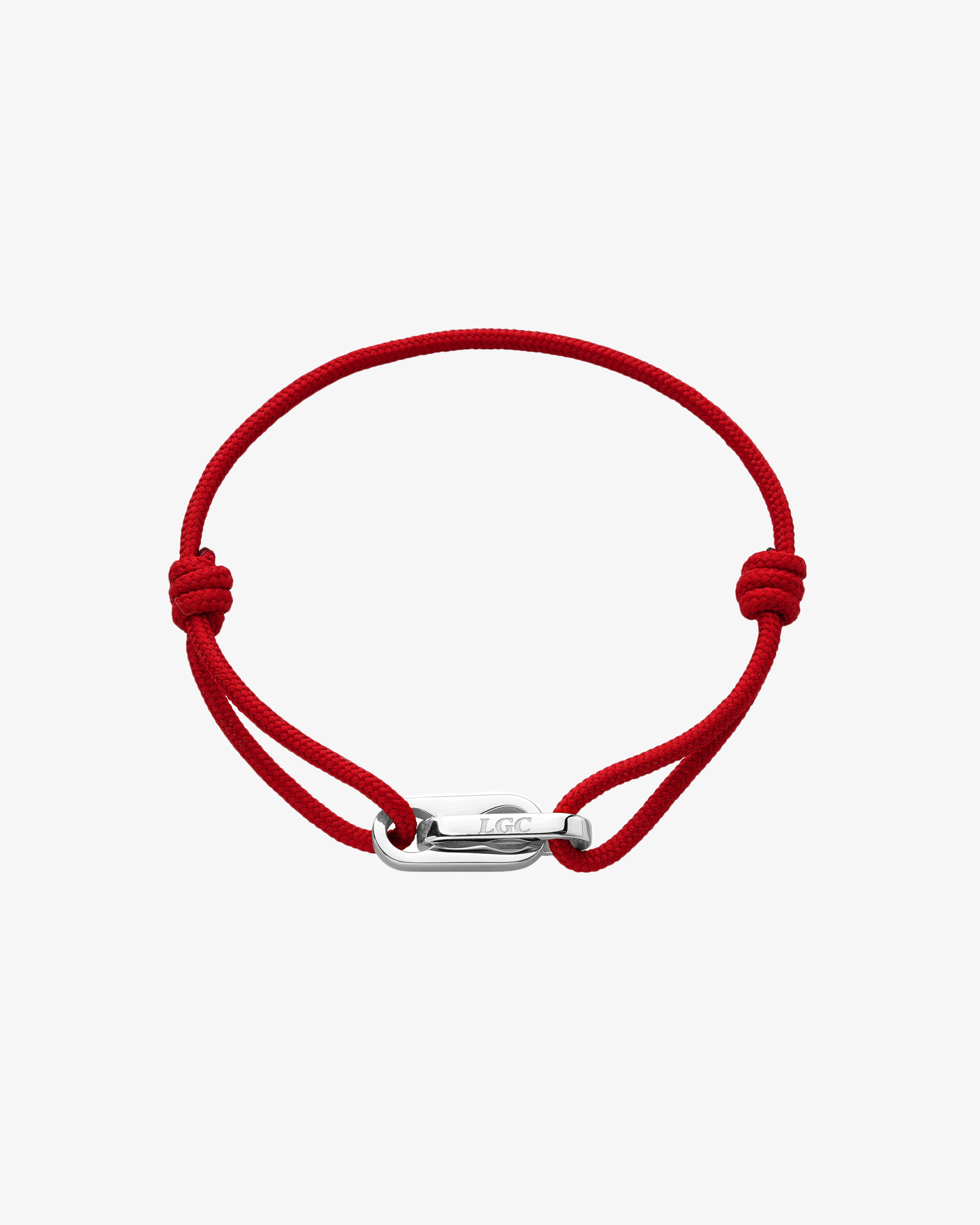 Red cord Atlantis bracelet with a silver engraved clasp on the wrist