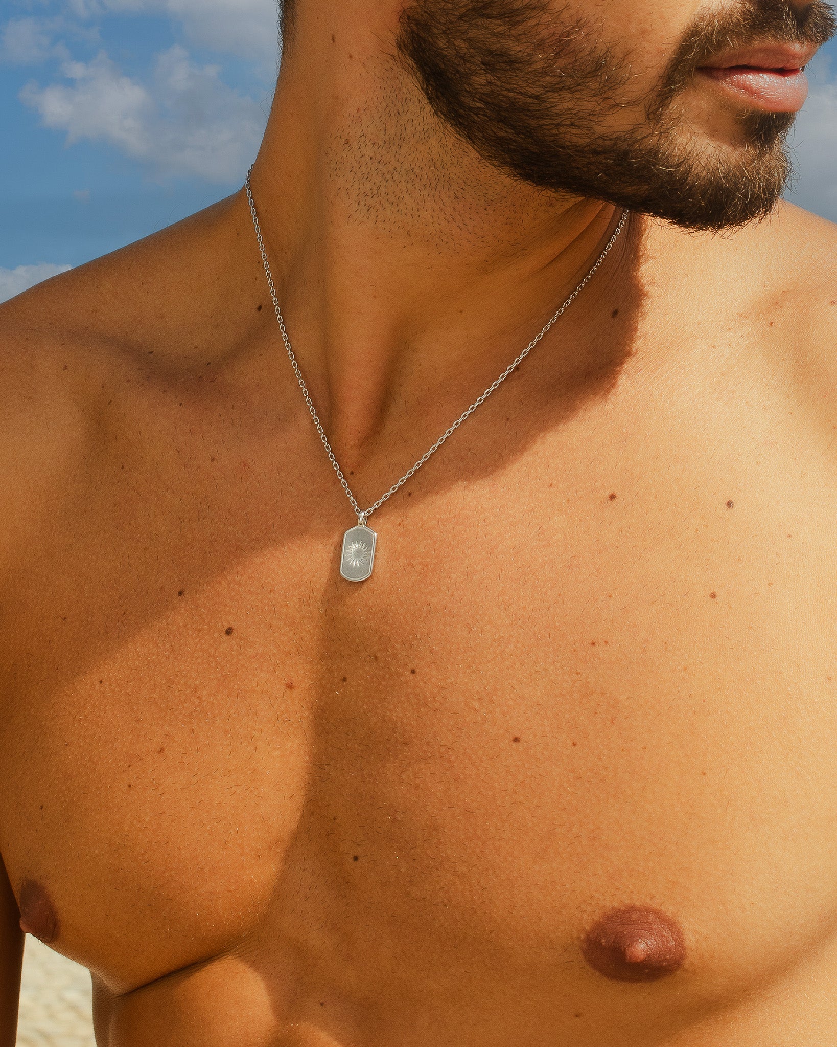 Collar plateado Daystar con colgante rectangular sobre el pecho de un hombre