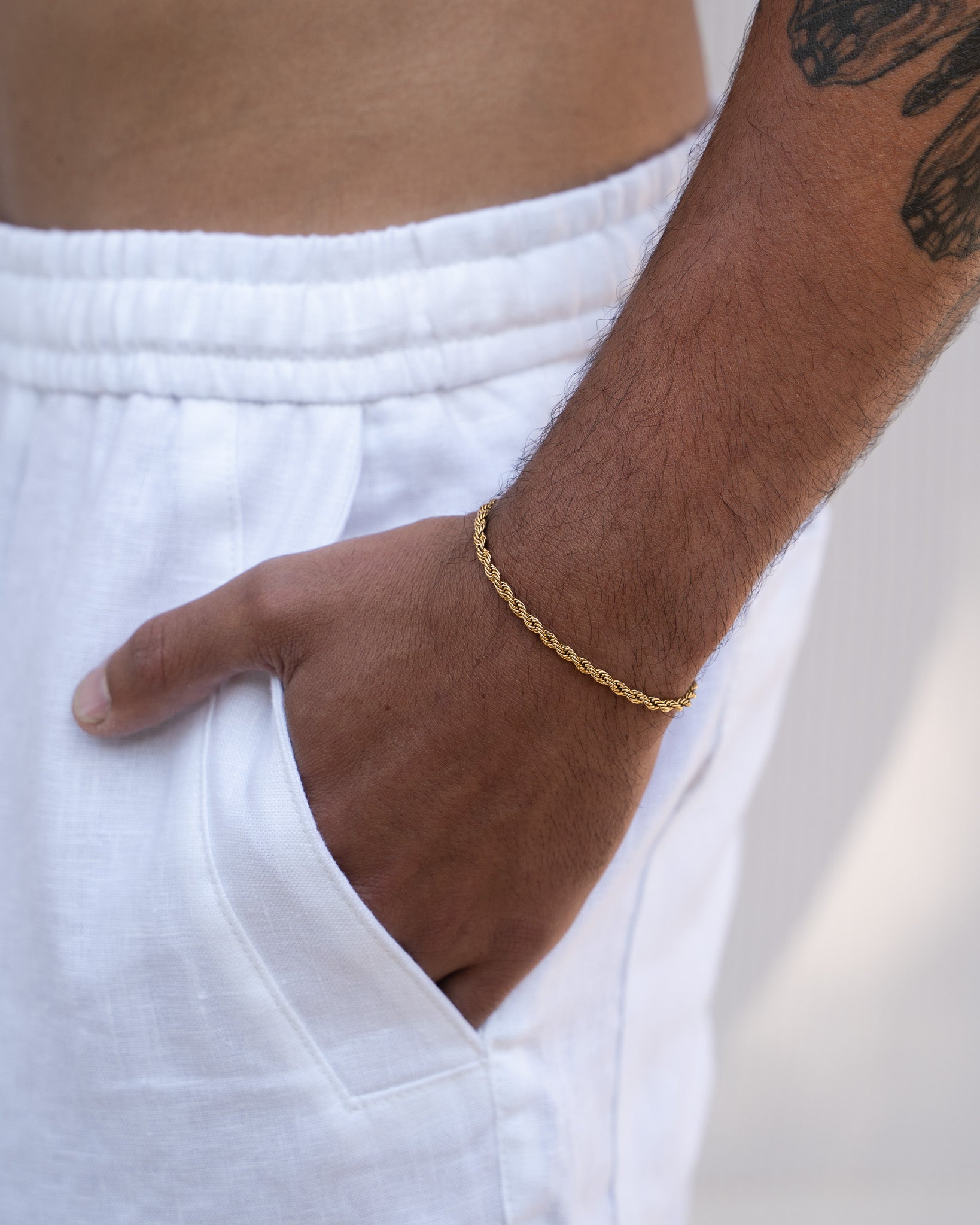Lazio gold rope chain bracelet worn on the wrist with white shorts in the background