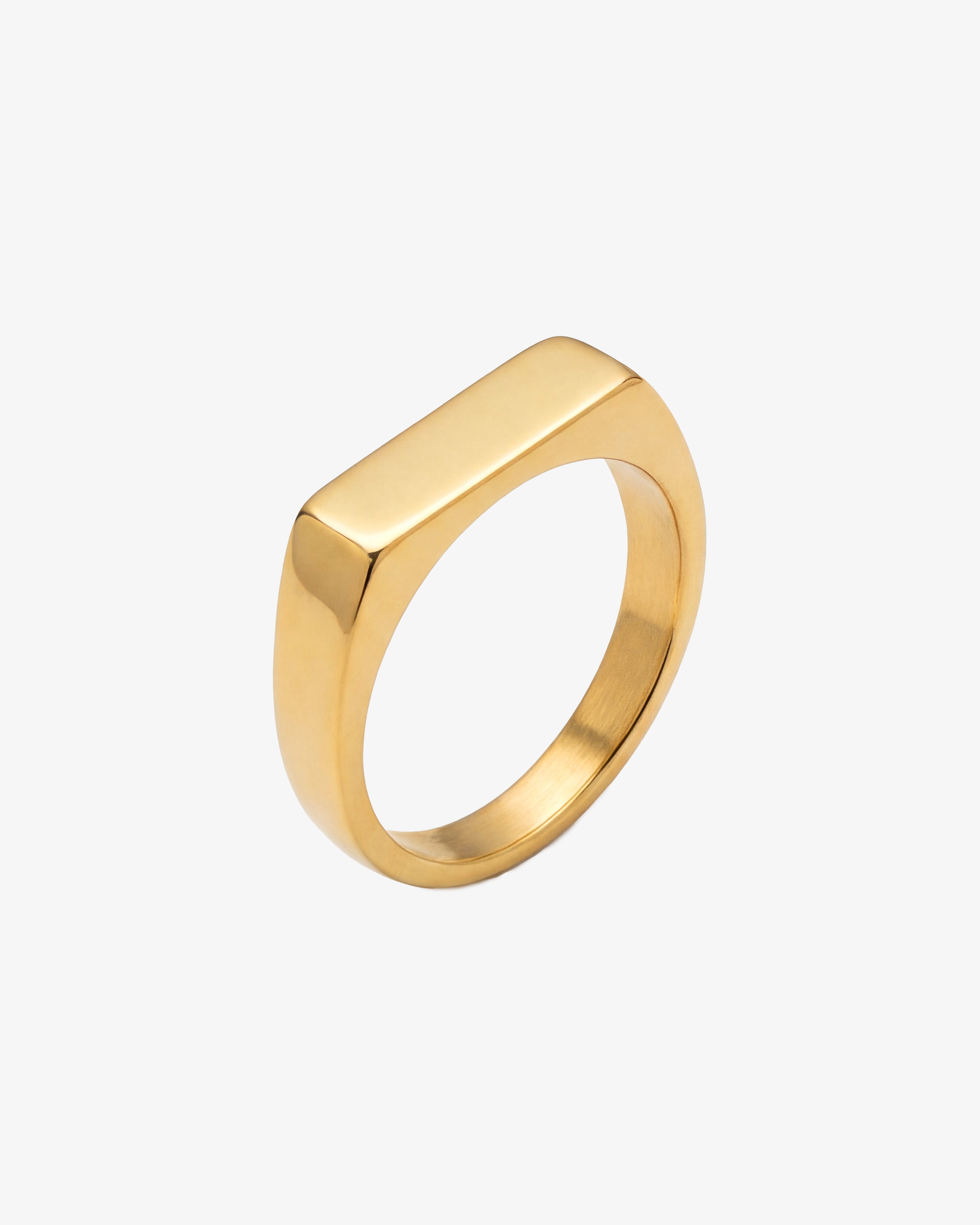Gold chain bracelet on the wrist with a matching gold ring on the finger.