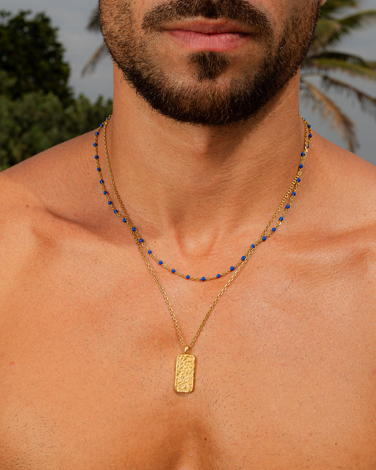 Collar MOONROCK de oro con cuentas azules en un hombre, primer plano de cuello y barba