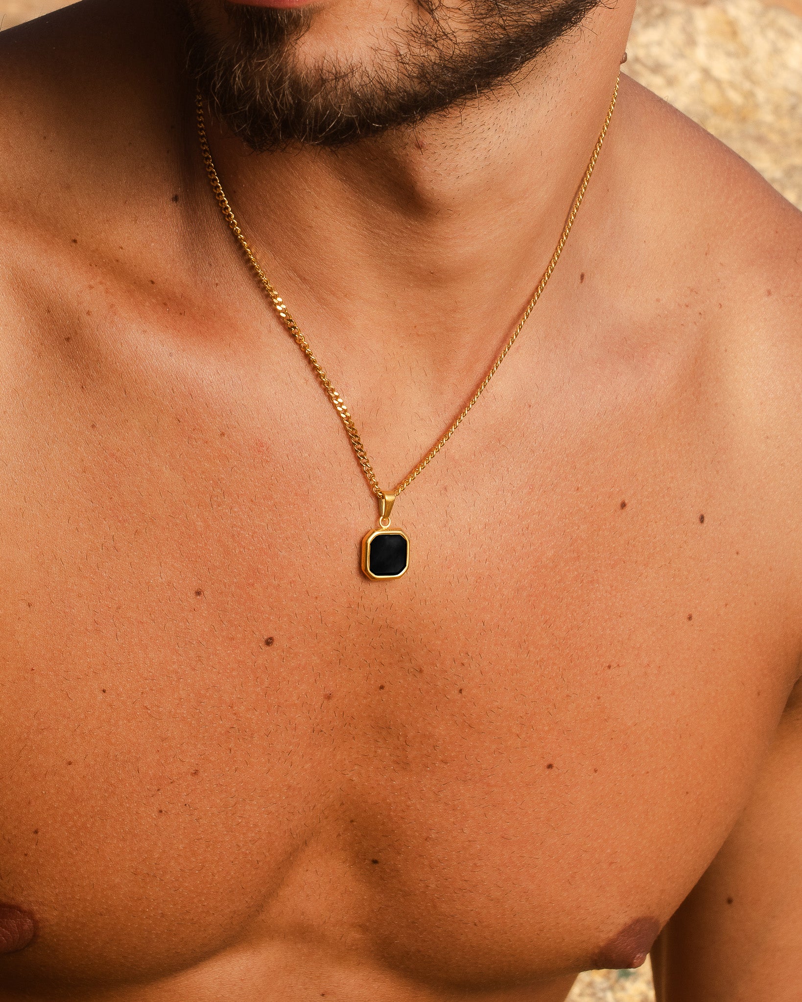 Collar dorado Nova mostrado desde otro ángulo con el colgante cuadrado negro sobre el pecho