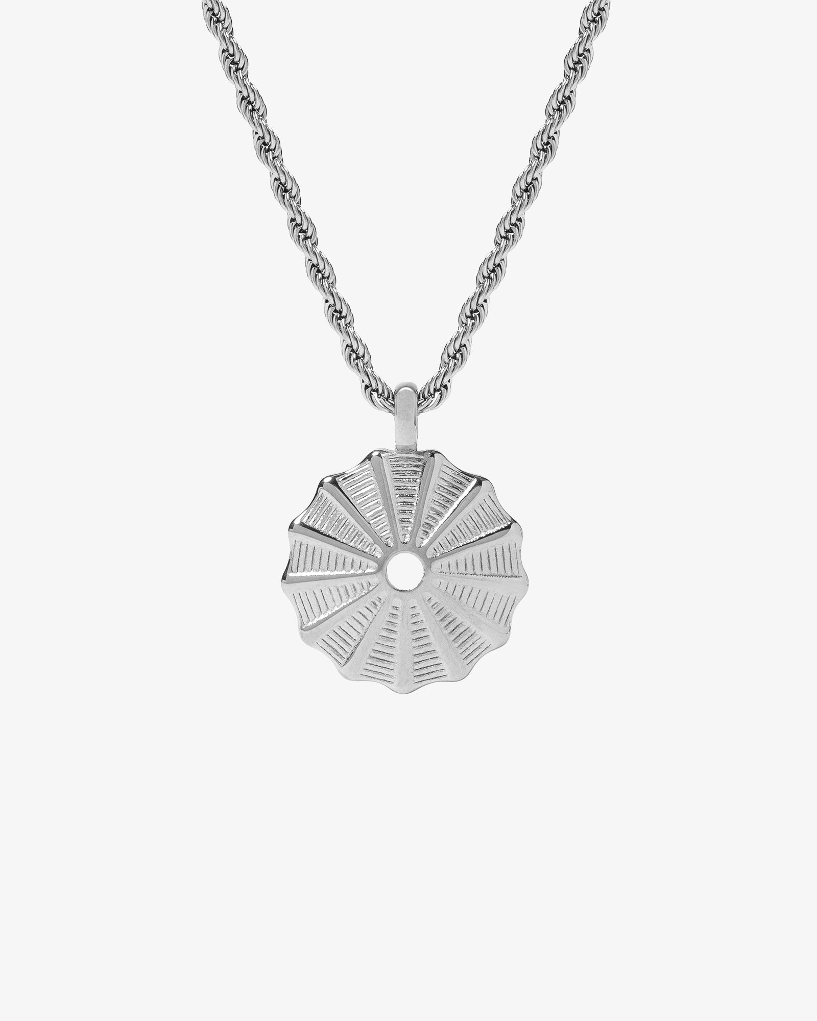 Silk Silver Necklace with a round sunburst pendant on a silver chain against white background.