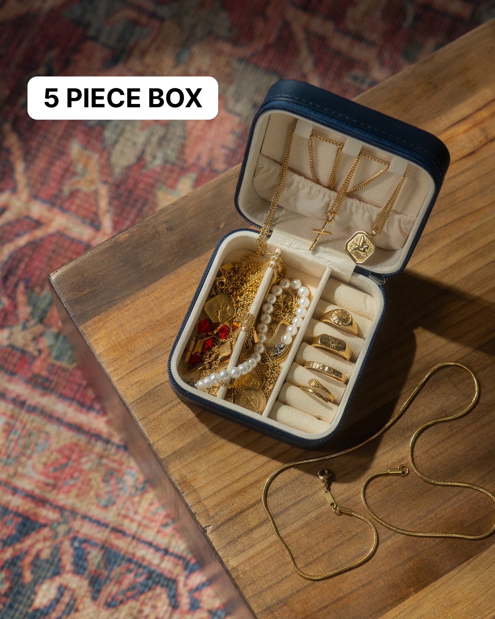 Open jewelry box filled with gold chains bracelets and pearl jewelry arranged in compartments