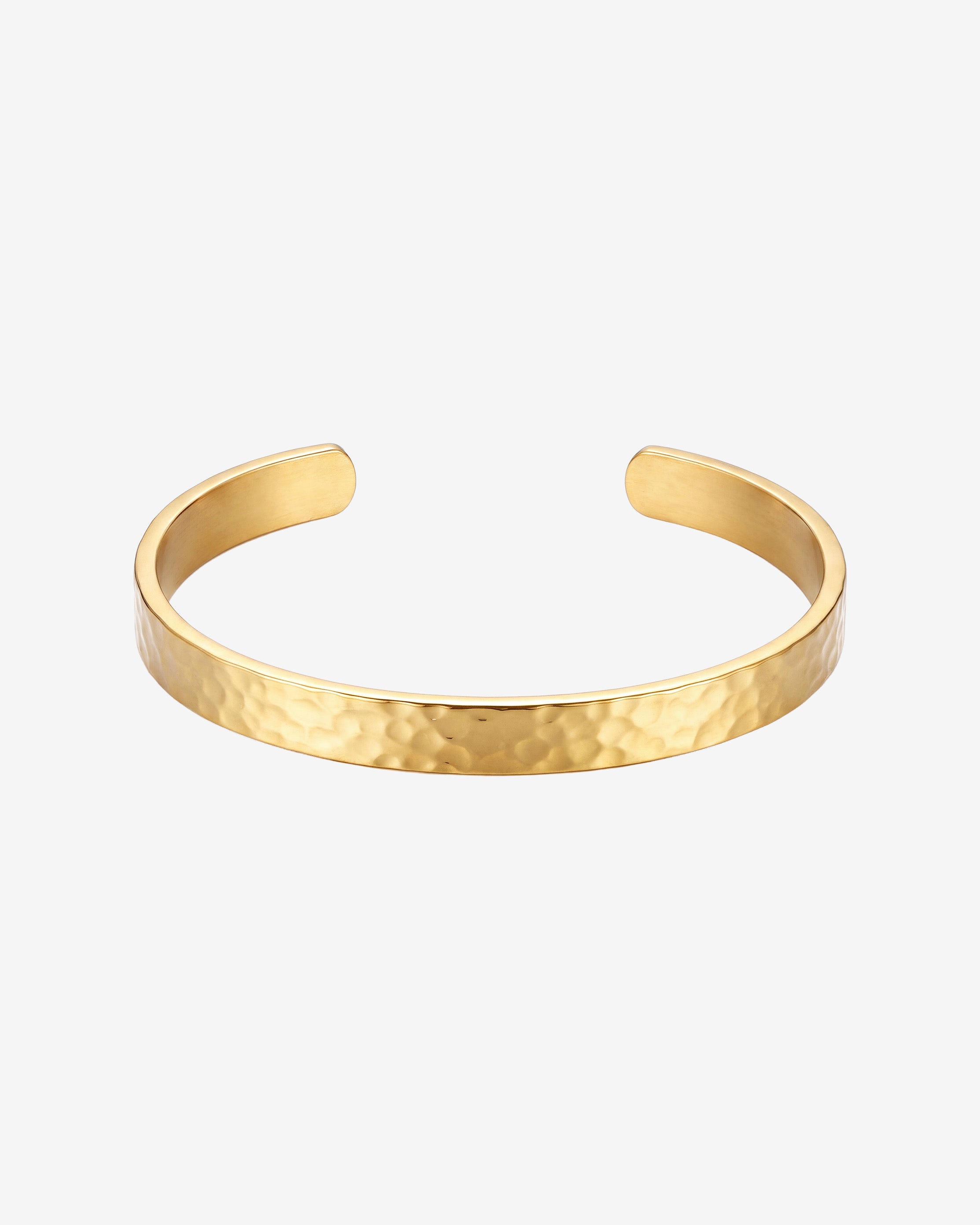 Hammered gold bracelet with open ends on a light background