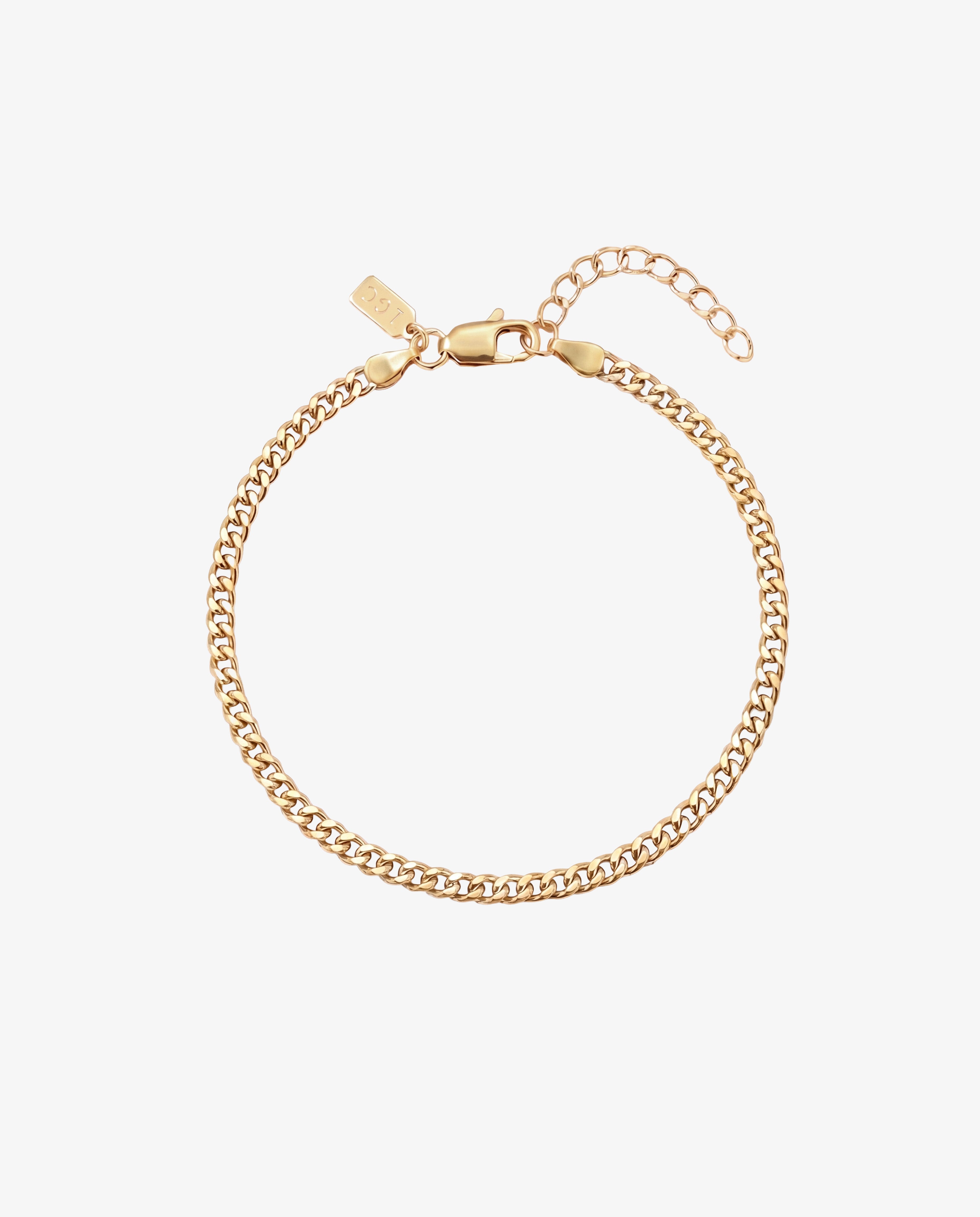 Primer plano de la pulsera KUBU de oro con cierre de mosquetón y cadena extensora sobre fondo blanco