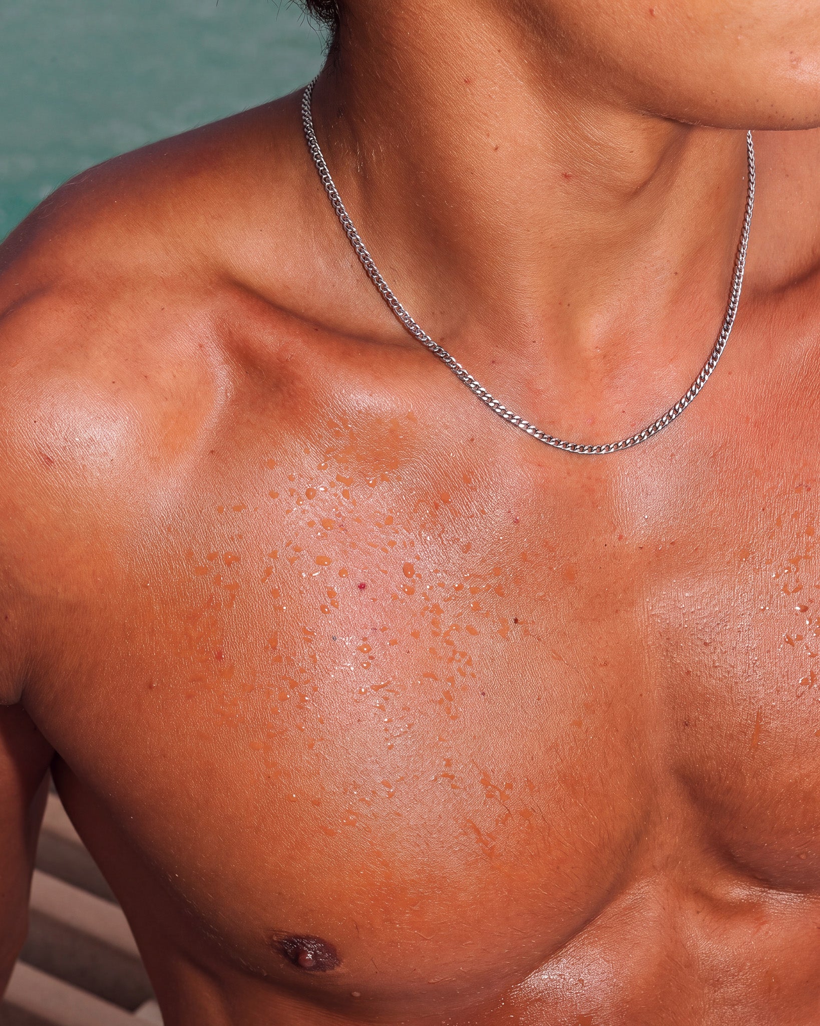 Cadena KUBU de plata en el cuello y la clavícula desnudos de un modelo.