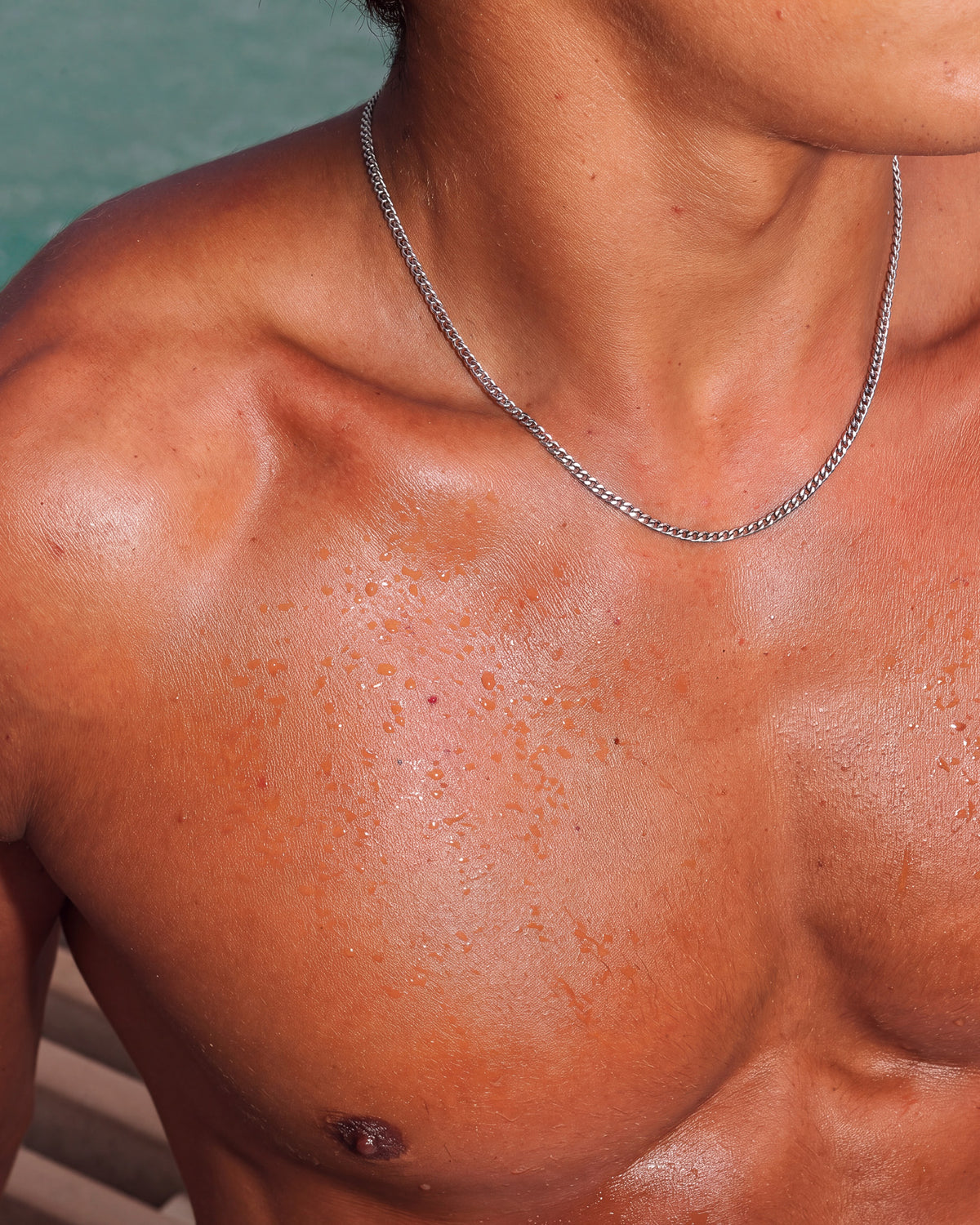 Cadena KUBU de plata en el cuello y la clavícula desnudos de un modelo.