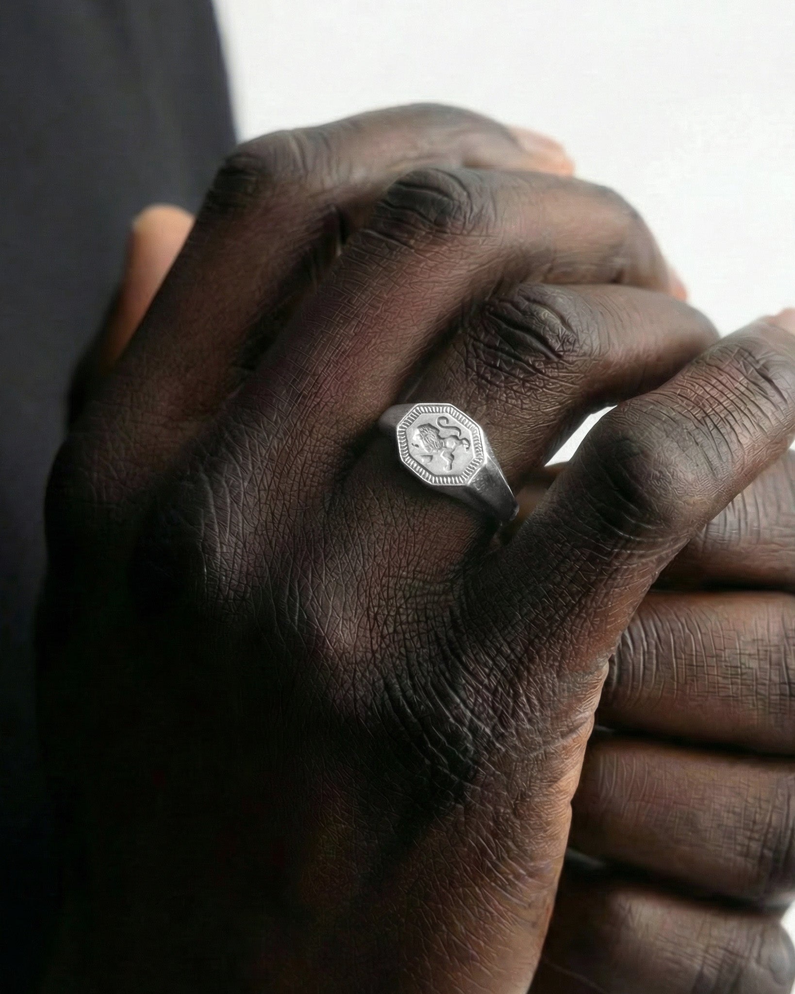 Legacy Silver Ring with octagonal engraved bezel on a dark-skinned hand.