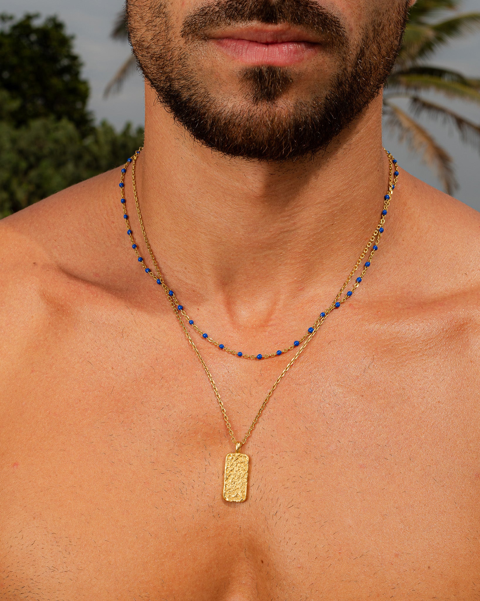 Collar MOONROCK de oro con cuentas azules en un hombre, primer plano de cuello y barba