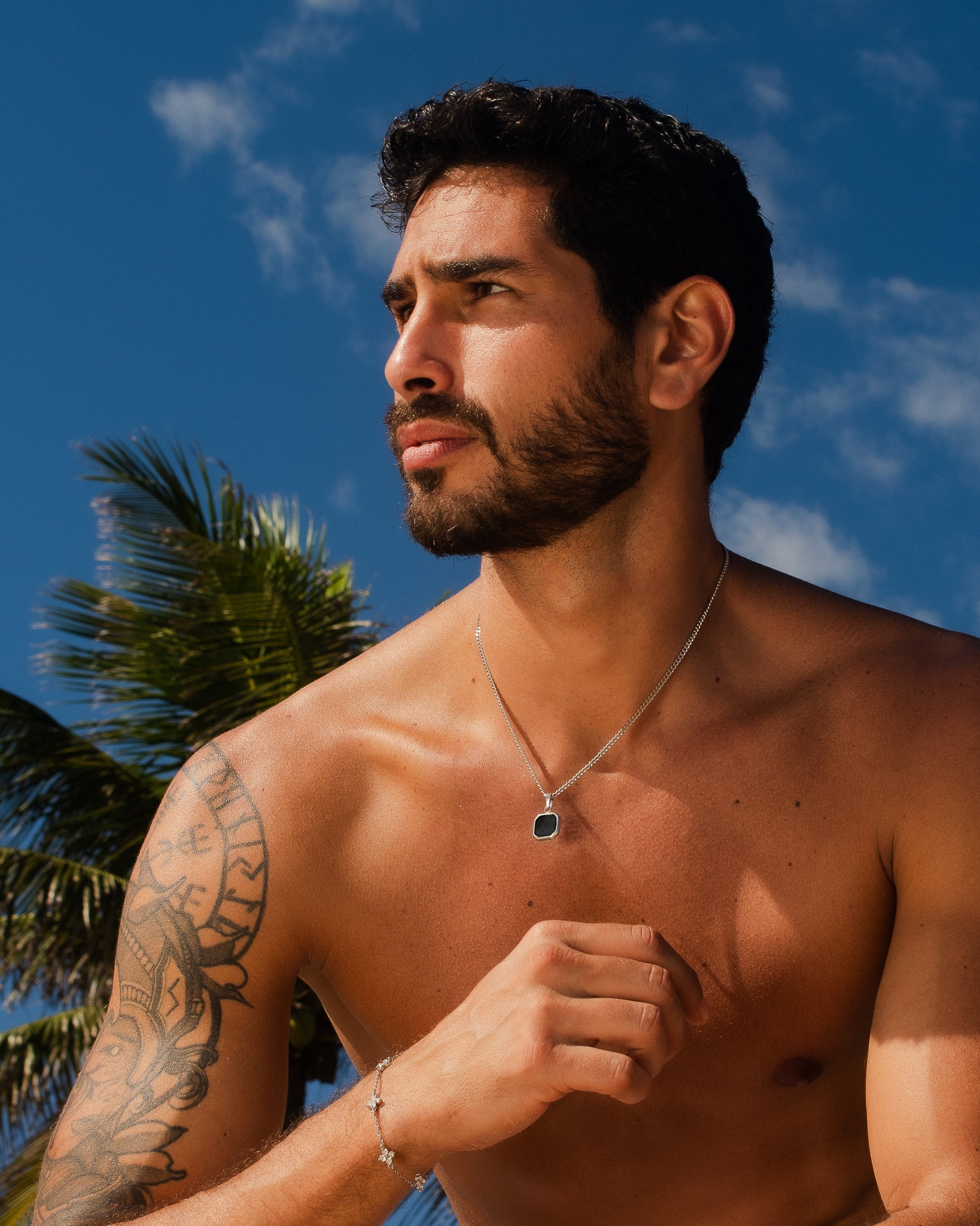 Nova Silver Necklace pendant with a black octagonal stone in a silver bezel on a man's chest