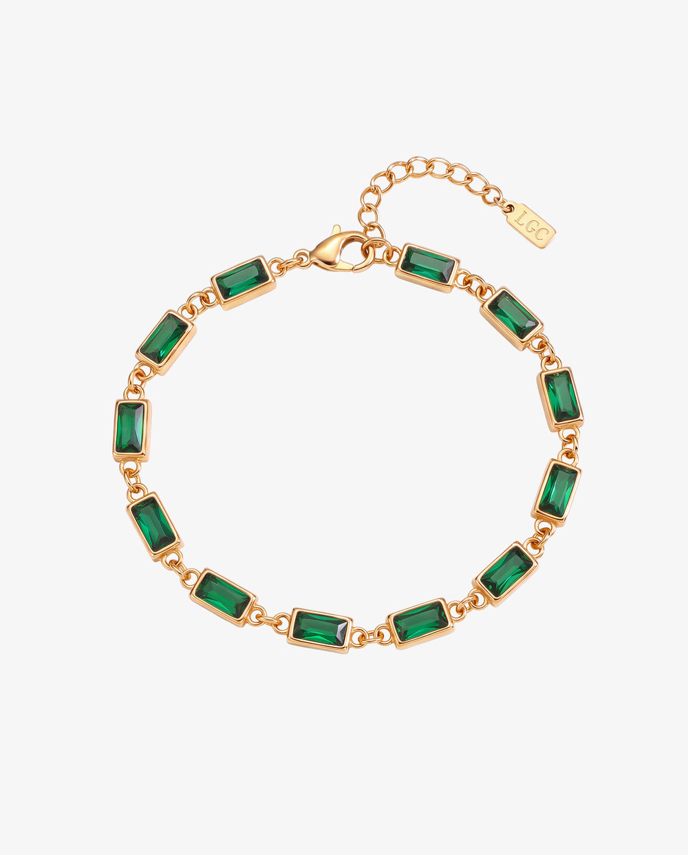 Pulsera de oro con piedras rectangulares verde esmeralda engarzadas en cadena de oro sobre fondo blanco