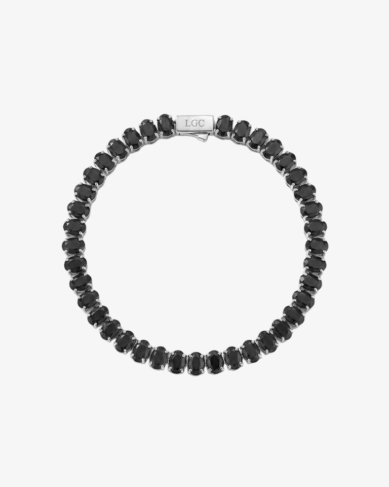 Pulsera tennis de circonitas negras ovaladas extendida sobre fondo blanco