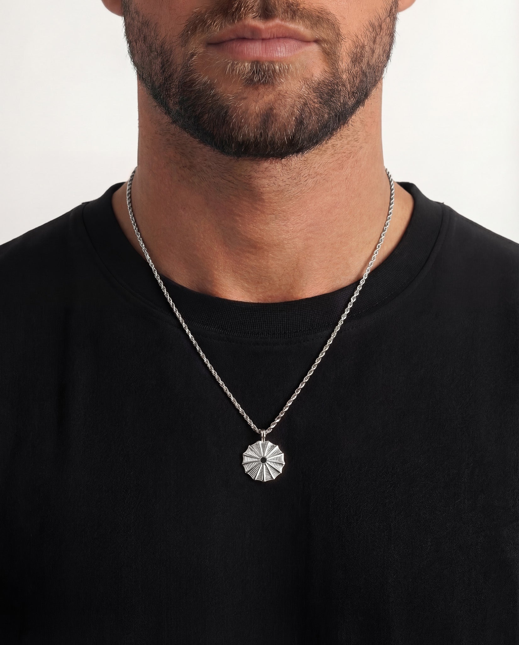 Silk Silver Necklace worn by a model, close up of the round sunburst pendant on the silver chain.