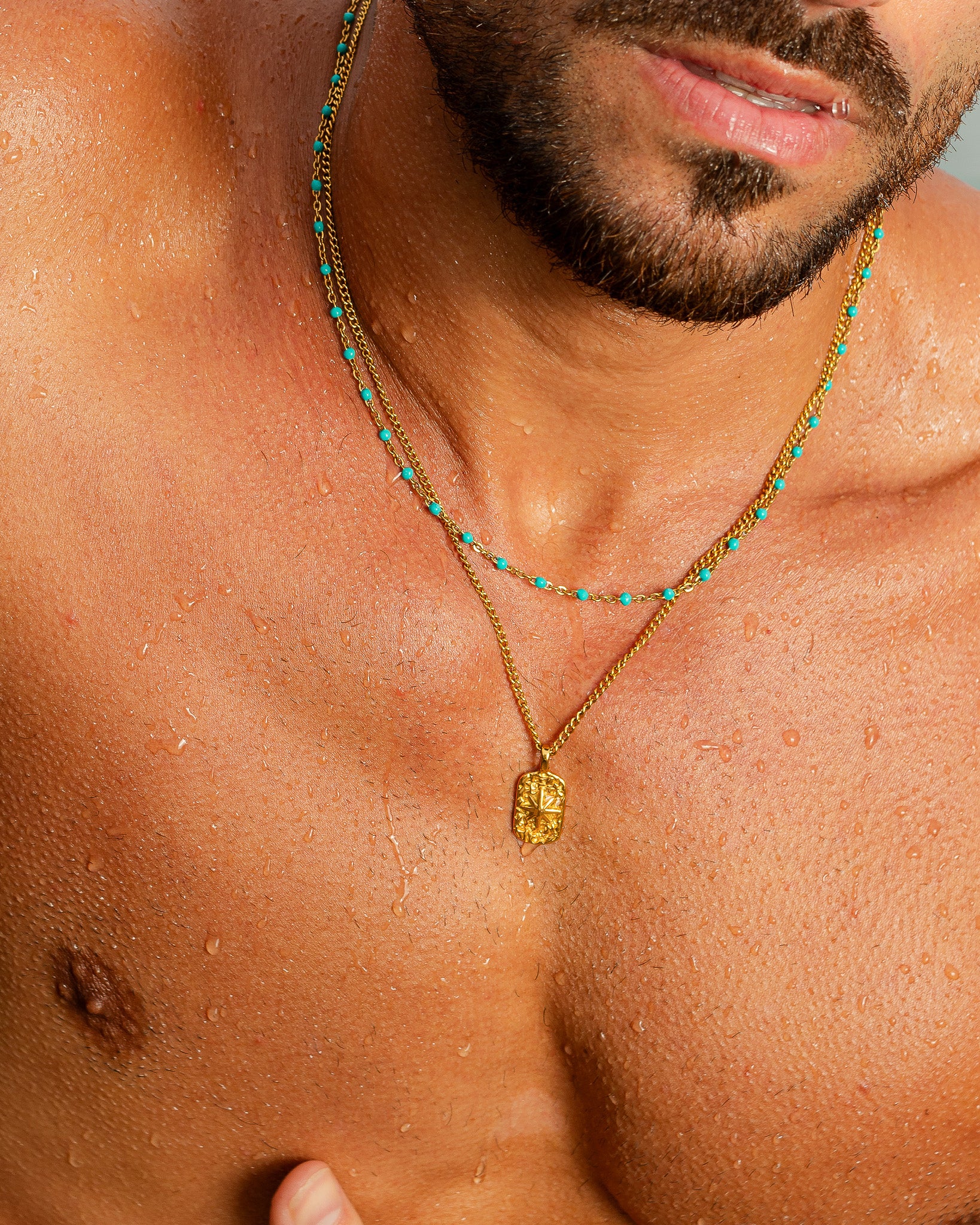 Collar de oro con cuentas turquesa y colgante rectangular tallado sobre el pecho